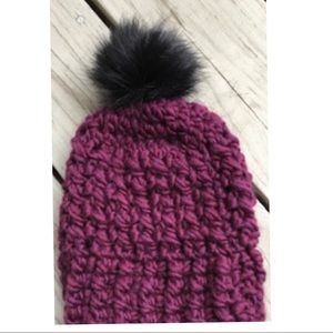 A Warm Child Hat with Black Faux Fur Pom Pom.